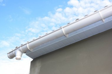 Çatı oluk tamiri. Cilt payı yükleme sahipleri ile yağmur, downspout boru drenaj. Bitmemiş Guttering ev.