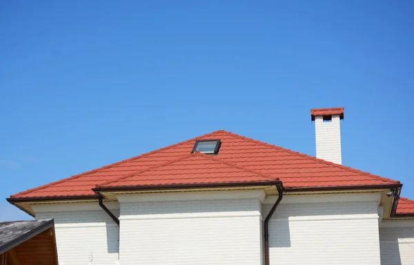 Close up on house attic skylight window with red metal roof, gutter, chimney and security cameras. — Stock Photo, Image