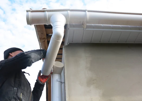 Roofer instalar y reparar el sistema de canalón. Instalación de canalón de lluvia con tubo descendente de drenaje . — Foto de Stock