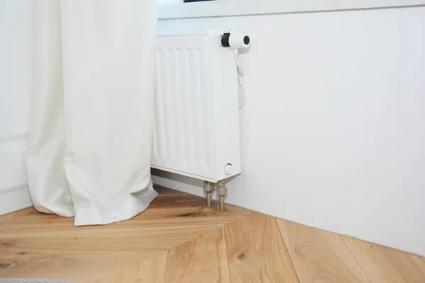 Calefacción radiador blanco con termostato para ahorro de energía, persianas blancas, suelo de madera . — Foto de Stock