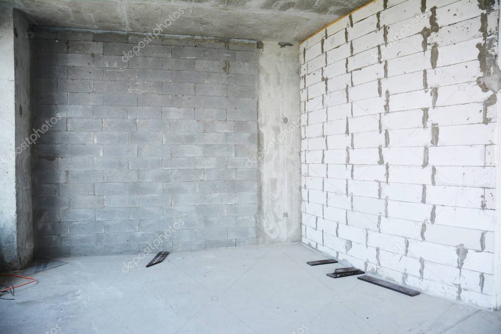 Empty room under construction with with unfinished plastering wall, drywalls, stucco.