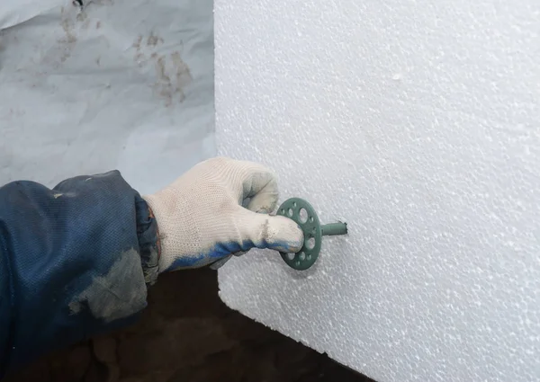 承包商安装发泡胶硬质隔热板。如何在混凝土墙体上附加硬质泡沫绝缘. — 图库照片