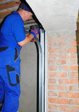 Kiev, Ukrayna - Kasım, 7, 2017: Yüklenici onarım ve garaj kapısı yüklemek. Kırık bir garaj kapı bahar yerine.