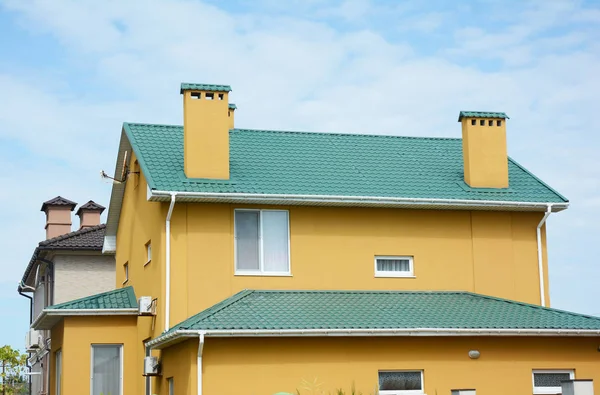 Réparer toit en métal avec rénover et remplacer les tuiles de toit en métal. Maison avec toit métallique, cheminée en brique, système de gouttière, climatiseur et mur en plâtre à l'extérieur . — Photo