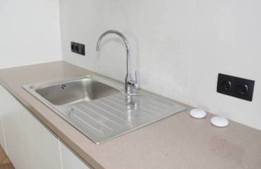 Modern mutfak metal musluk ve seramik lavabo.