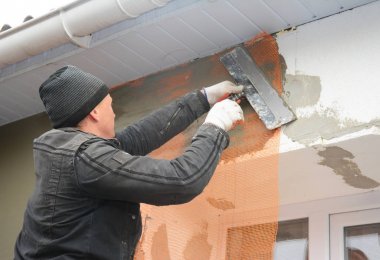 Yüklenici sıva duvar ile macun spatulası, cam elyaf örgü, örgü sonra katı yalıtım alçı. Ev duvar sorun alanı izolasyonu ile sıva duvar.