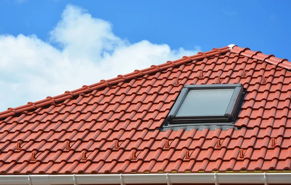 Claraboyas de la ventana del ático en el techo de tejas de arcilla roja . — Foto de Stock