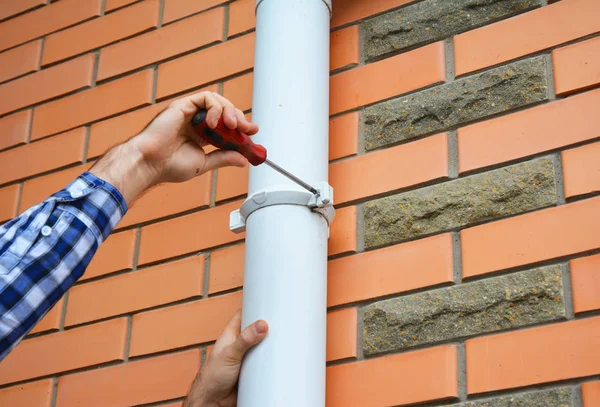 Werknemer installeren regen goot regenpijp pijp. — Stockfoto