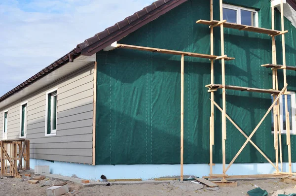 Building house with wall insulation, waterpfoof membrane, plastic siding, guttering and foundation insulation with styrofoam — Stock Photo, Image