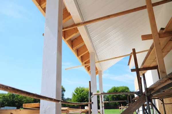 Gebäude Haus Terrassenüberdachung mit hölzernen Säulen und unfertigen Soffits und Faszienplatten Installation. — Stockfoto