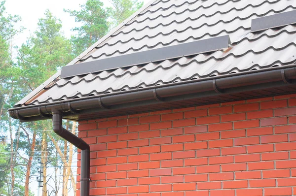 Construção de telhados de metal com sistema de calha de chuva e proteção contra telhado de placa de neve . — Fotografia de Stock