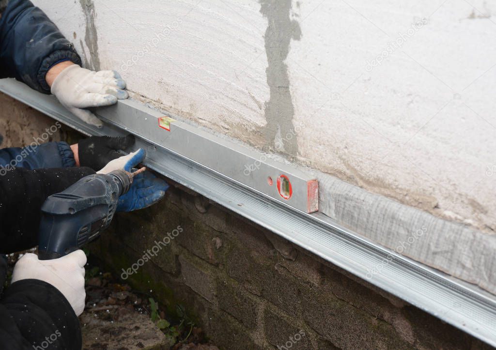 Old house foundation wall repair and renovation  with installing metal sheets for waterproofing and protect from rain.