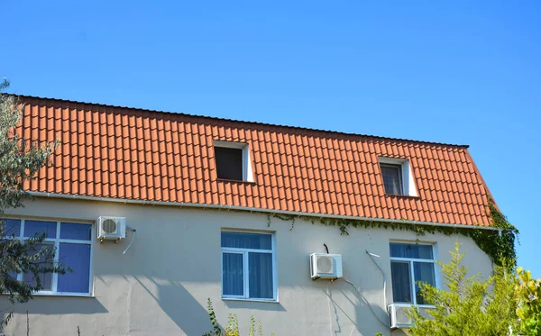 Закрыться на доме с металлической крышей, мансардой, окном, воздуховодом, кондиционером . — стоковое фото