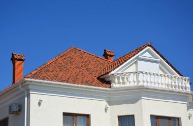 İnşaat çatı kaplama doğal kil kiremit, evin tavan balkon ve metal panjurlar, güneşlikler.
