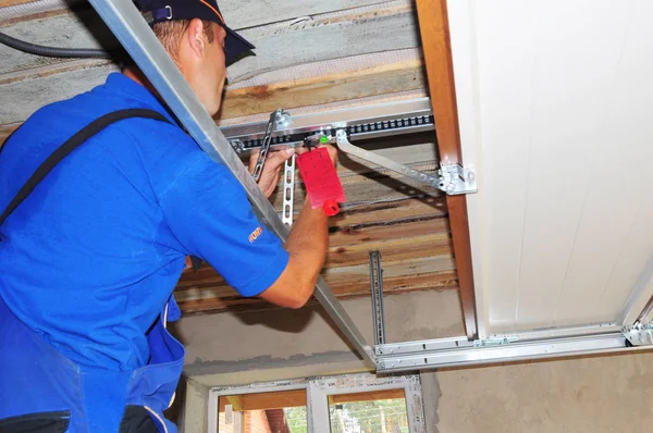 Garaj kapısı açacağı sistemi yükleme işçi. Garaj kapısını tamir.