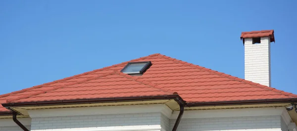 Huis met natuurlijke dakpannen, zolder dakraam windows. Thuis Guttering, dakgoten, kunststof goothoogte systeem. — Stockfoto