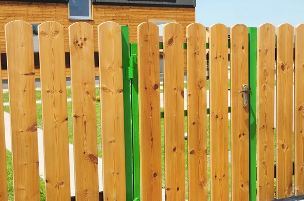 Wooden garden fence door. Wood fence - house wood fencing.