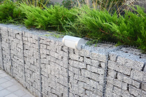 Gabion fence with stones in wire mesh and outdoor lighting. Gabion wire mesh fencing — Stock Photo, Image