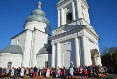 Nizhyn, Ukrayna - 7 Nisan 2018: Ukraynalı Ortodoks Rahip kutsal su müminler ve pişmiş geleneksel Ortodoks paska sprinkles, Ortodoks Paskalya'da yumurta