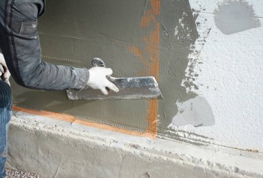 Yüklenici sıva duvar spatula, fiberglas ağ, ile alçı kafes sonra katı yalıtım.
