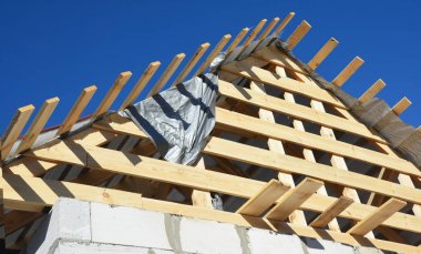 Çatı inşaat. Yeni ev ahşap kirişleri, günlükleri, saçak, ahşap yükleme.