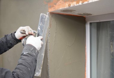 Yüklenici bina fiberglas fileli sıva duvar, sıva, kafes pencere pervazına sorun alanı içinde katı yalıtım sonra alçı.