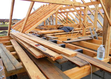 Evin çatı inşaat panorama. Su geçirmez maddeler, ahşap kirişleri, saçak, yükleme bitüm ve kereste ile günlüğe kaydeder.