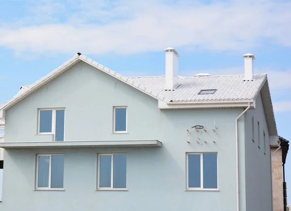 Modern white color house with unfinished balcony, attic skylight window, white tiles roof outdoors — Stock Photo, Image