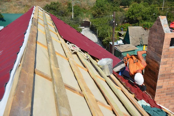 Dachdecker verlegt Dach mit leichten Metalldachziegeln im Problembereich. Stahlziegeldachkonstruktion auf Hausdach — Stockfoto