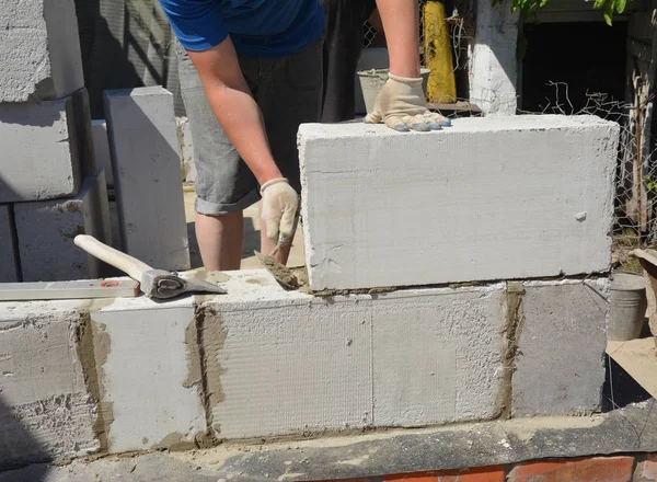 Bricklayer builder laying autoclaved aerated concrete blocks, aac for new house wall. Autoclaved aerated concrete blocks walling installation — Stock Image Bricklayer builder laying autoclaved aerated concrete blocks, aac for new house wall. Autoclaved aerated concrete blocks walling installation Royalty Free Stock Photos