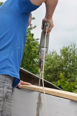 Çatı ustası sondaj evi duvarına, duvarın tepesine Woden kirişler monte etmek için.