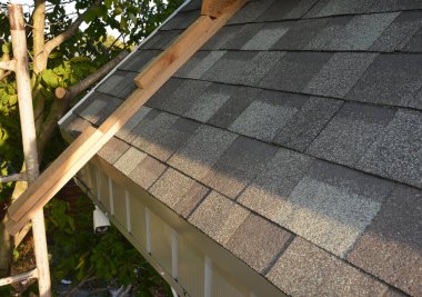 Roofing Construction.  Installing, Repair, Renovate  Asphalt Shingles Roof Tiles on the Rooftop Outdoors