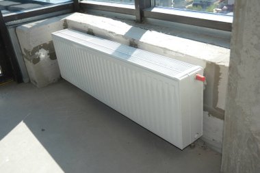 Ev yapımı ısıtma sistemi ve radyatör ısıtma sistemi. Evde radyatör ısıtıcısı kuruluyor. Beyaz metal radyatör ısıtma kurulumu.