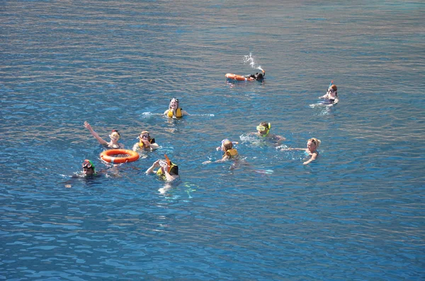 SHARM EL SHEIKH, EGITO - NOVEMBRO 18,2019: Grupo de pessoas felizes nadando em mar aberto, perto do recife em máscaras de mergulho. Estilo de vida de viagem, esporte aquático aventura ao ar livre, aulas de natação no verão — Fotografia de Stock