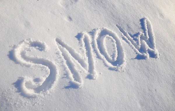 The words SNOW are written in snow. Written word on a snow white field.