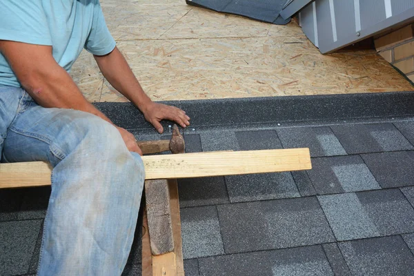 Contratista de techos instalando culebrillas de asfalto en el techo de la casa osb board. Construcción de techos —  Fotos de Stock