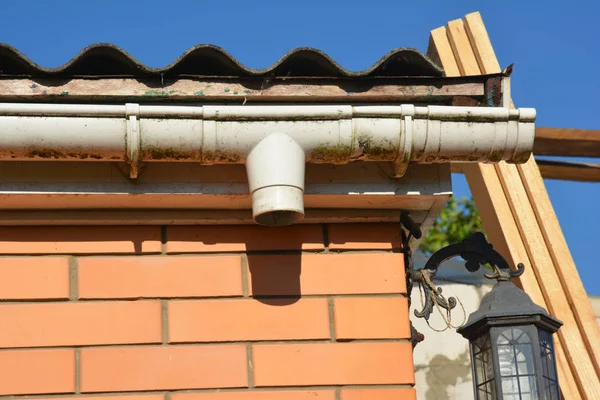 Casa de ladrillo y reparación de canaletas de lluvia. Fijación de alcantarilla —  Fotos de Stock