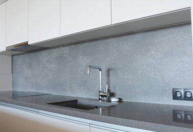 Musluğu, mutfak kaputu, musluğu, masa elektrikli fırını olan modern mutfak..