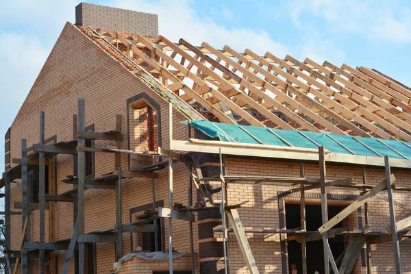 Huis dak houten frame bouw. Onvolledig dak dak constructie spanten, damp barrière, houten balken, dakrand, hout — Stockfoto