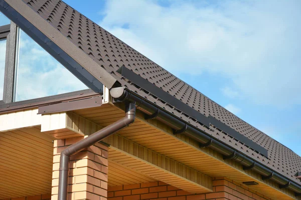 Canto do telhado da casa com janela panorâmica sótão clarabóia e calha de chuva com duto downspout . — Fotografia de Stock