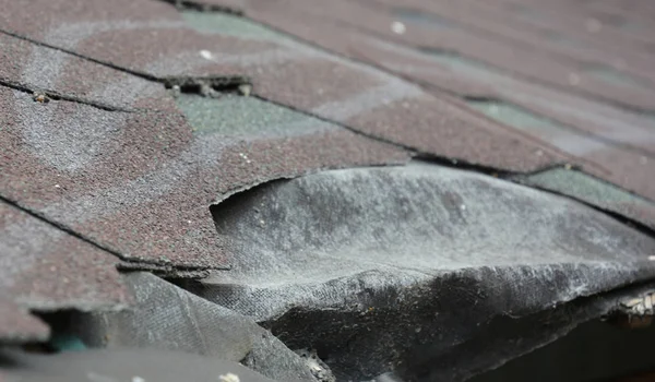 Uszkodzony dach domu gontów asfaltowych, dach uszkodzony — Zdjęcie stockowe
