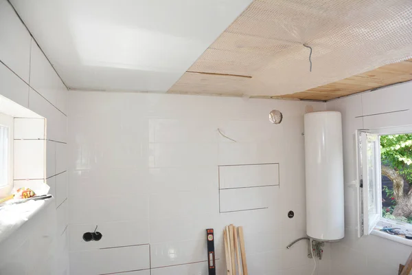 Instalación de tableros de techo de PVC blanco en el nuevo baño — Foto de Stock