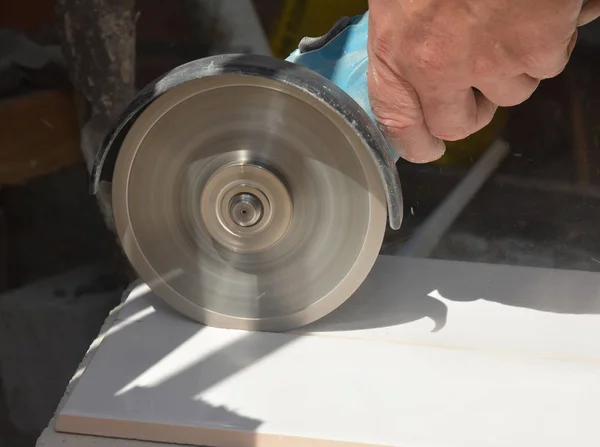 Worker cutting ceramic tile with disc grinder machine — 스톡 사진