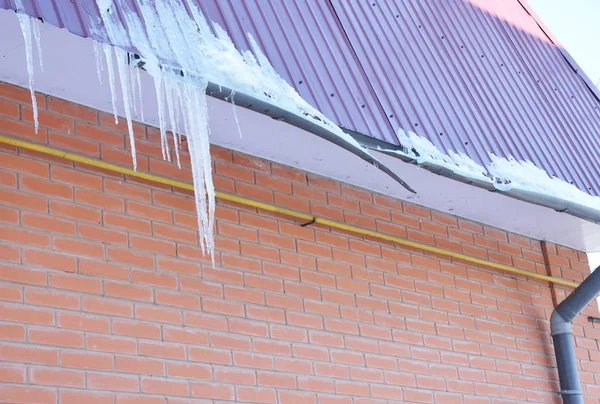 Casa tetto grondaia danneggiata da ghiaccio e neve bagnata pesante. Rotto casa tetto grondaia conduttura da ghiaccioli . — Foto Stock