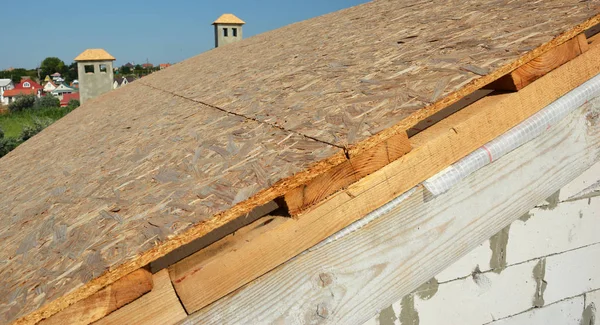 Tetőfedő építési ház tető burkolat orientált szál táblák (Osb) előtt aszfalt zsindely telepítés. — Stock Fotó