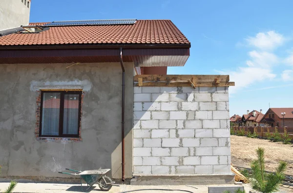 Casa in costruzione con finestra lucernario soffitta, impianto solare di riscaldamento dell'acqua, grondaia tetto, vernice e pareti intonacate . — Foto Stock