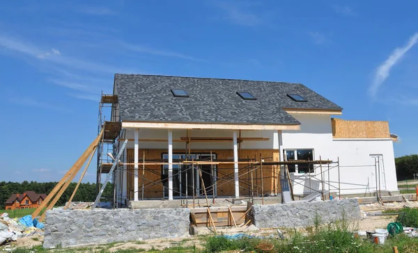 Ház felújítás homlokzat fali szigeteléssel, vakolat, paiting falak. Átalakító ház építési homlokzat állványzattal szabadban. — Stock Fotó
