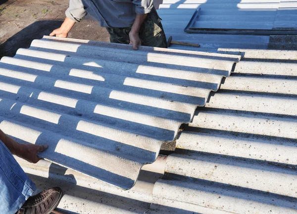 Remoção de amianto. Empreiteiros de telhados substituem telhas danificadas de amianto . — Fotografia de Stock