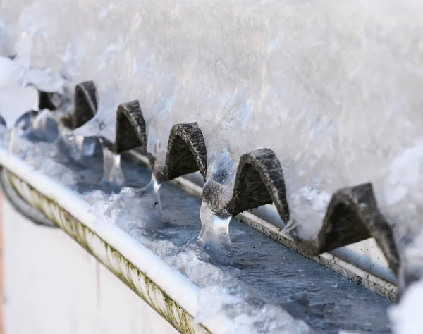 Casa congelada techo canalón de lluvia lleno de hielo en invierno — Foto de Stock