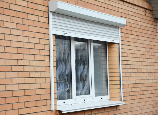 Backsteinhaus-Fenster mit Rollladen zum Schutz der Wohnung. — Stockfoto